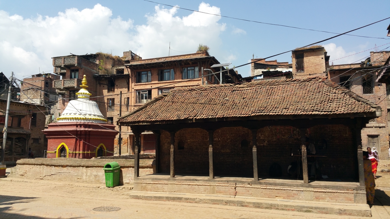 Ein Priester bereitet seinen Münzverkaufsstand vor. Mit Münzen wird kaum bezahlt, sie werden nur in Brunnen geworfen. Von dort kommen sie wieder über die Verkäufe von Priestern in den Umlauf.
