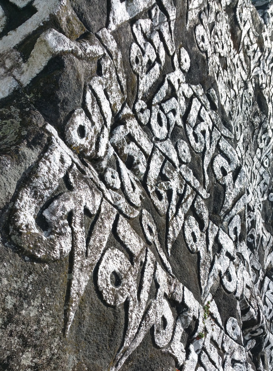 Heiliger Text auf einem großen Manistein.
