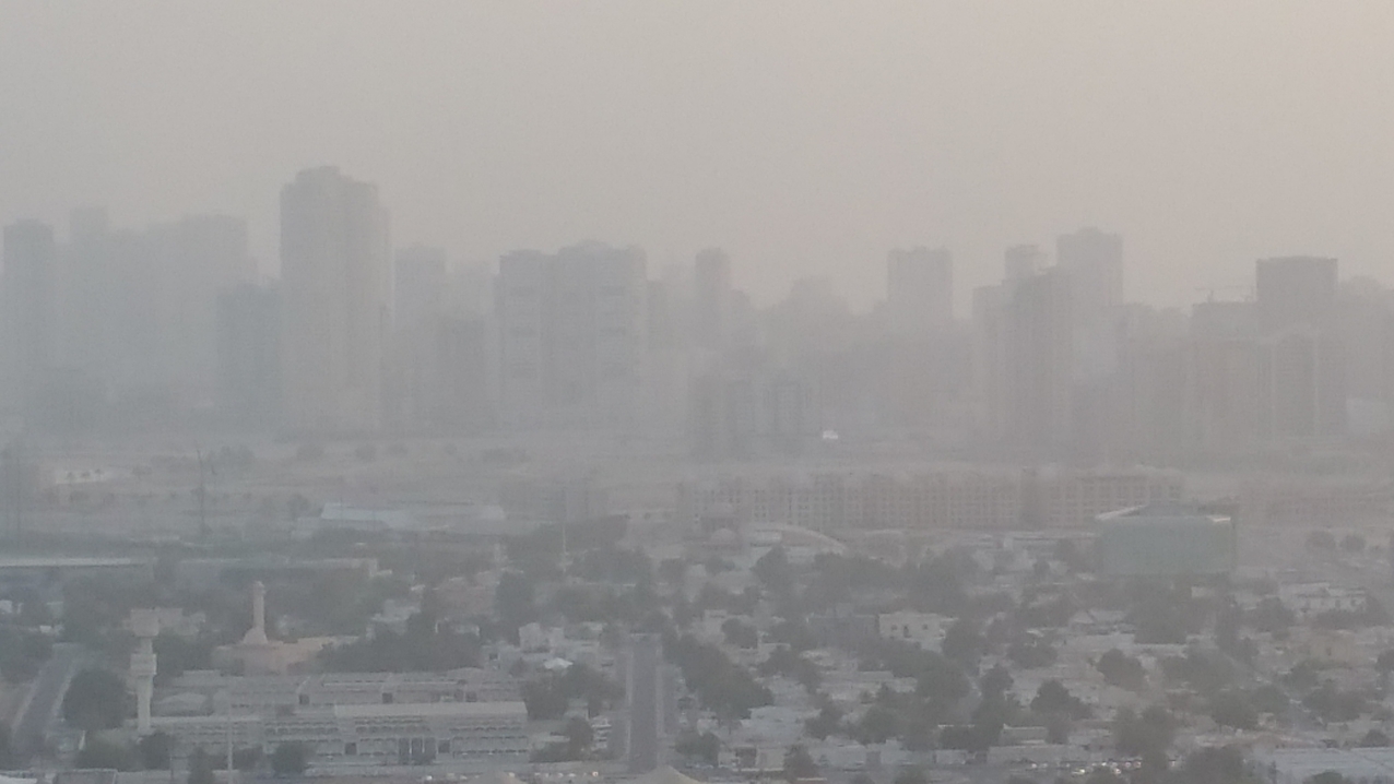 Anflug auf Dubai. Im Dunst die Hochhäuser der City.
